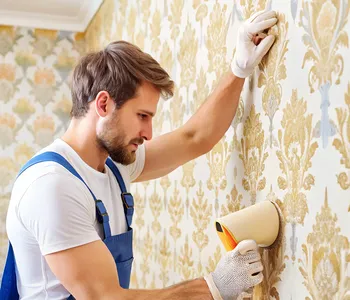 Handwerker beim Anbringen von Tapeten an einer Wand